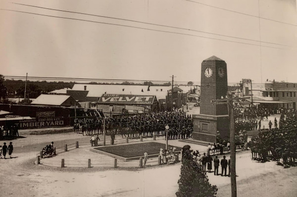The Corowa War Memorial clock tower on Sanger Street at its dedication in 1922, with mounted troops and crowds gathered around it.